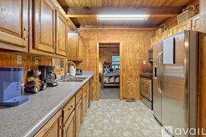 Rabun Gap house for rent - A kitchen with wooden cabinets and a stainless steel refrigerator.