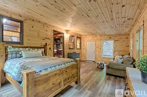 Rabun Gap house for rent - A bedroom with a large bed and wooden furnishings.