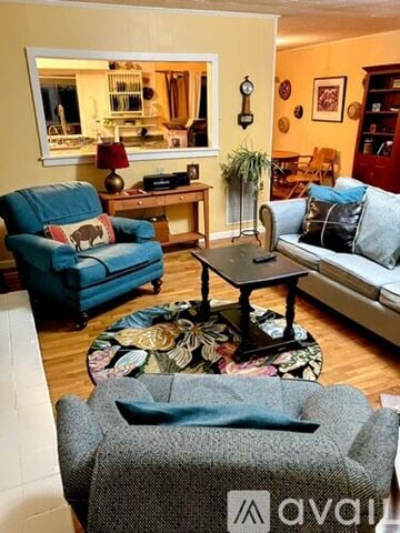 Clayton apartment for rent - A living room with a grey sofa and a blue armchair.
