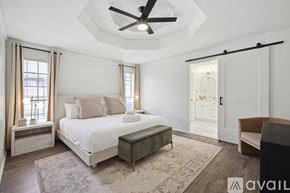 Allen house for rent - A bedroom with a bed, a bench, a ceiling fan, and a rug.