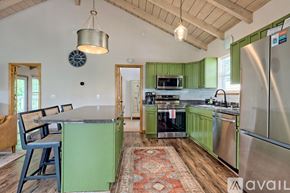 Clayton house for rent - A kitchen with green cabinets and a stainless steel refrigerator.