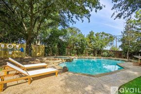 Flower Mound house for rent - A pool surrounded by trees and a wooden deck.
