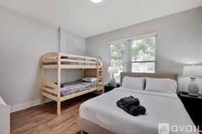 Flower Mound house for rent - A bedroom with a bunk bed and a single bed with towels on top.