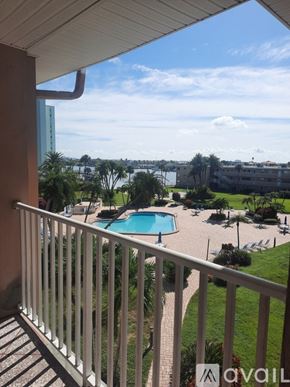 St. Pete Beach apartment for rent - A balcony overlooks a pool and a view of the city.