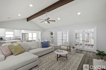 Fort Worth house for rent - A living room with a white couch and a ceiling fan.