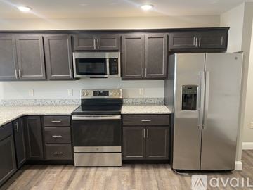 New Hartford apartment for rent - A kitchen with dark brown cabinets and stainless steel appliances.