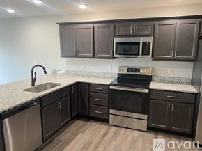 New Hartford apartment for rent - A kitchen with dark brown cabinets and stainless steel appliances.