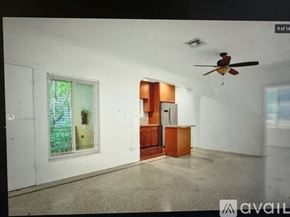 Miami Beach apartment for rent - A room with a ceiling fan and a door leading to another room.