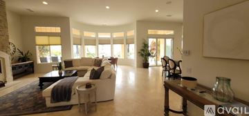 La Quinta house for rent - A spacious living room with a large couch and a long wooden bench.