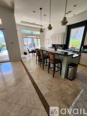 La Quinta house for rent - A kitchen with wooden cabinets and a black countertop.
