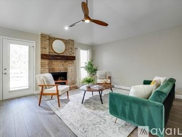 Lewisville house for rent - A living room with a green chair and a wooden table.
