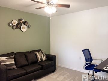 Ave Maria condo for rent - A living room with a black couch and a ceiling fan.