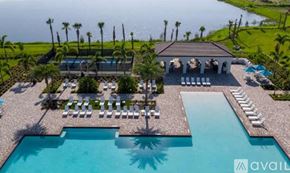 Ave Maria condo for rent - A large swimming pool with sun loungers and a building with a balcony overlooking the pool.
