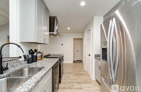 Friendswood house for rent - A modern kitchen with a stainless steel refrigerator and a marble countertop.