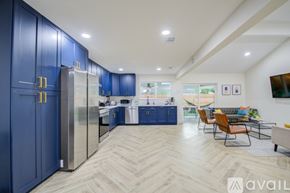 Friendswood house for rent - A kitchen with blue cabinets and a refrigerator.