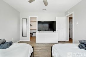 Lewisville house for rent - A bedroom with two beds and a television in the corner.