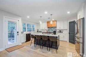 Spring house for rent - A kitchen with a table and chairs in the middle of it.