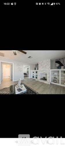 Surprise house for rent - A modern living room with a white sofa and a black rug.