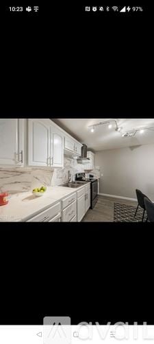 Surprise house for rent - A kitchen with white cabinets and a black chair.