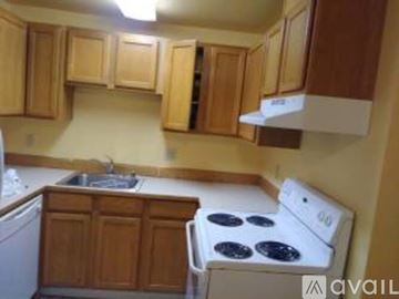 Lynnwood apartment for rent - A kitchen with wooden cabinets and a white stove top oven.