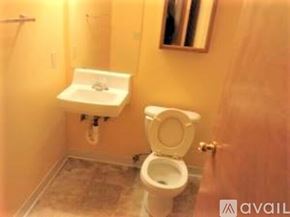 Lynnwood apartment for rent - A bathroom with a toilet, sink, and mirror.