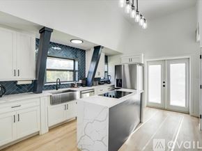 Denton house for rent - A modern kitchen with white cabinets and a central island.