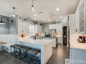 Lewisville house for rent - A modern kitchen with white cabinets and a central island.