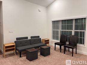 Tavares house for rent - A living room with a grey couch, two black chairs, and a small wooden table.