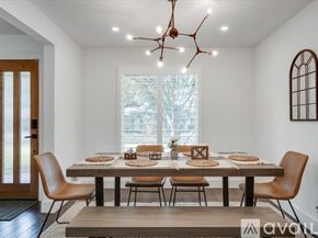 Plano house for rent - A modern dining room with a large table set for a meal.