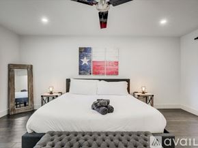 Plano house for rent - A bedroom with a large bed and a Texas flag on the wall.