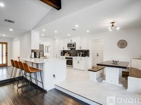Plano house for rent - A modern kitchen with white cabinets and a wooden island.