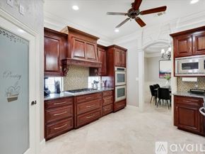 Kennedale house for rent - A kitchen with brown cabinets and a ceiling fan.