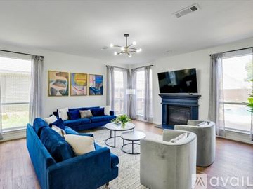 Haltom City house for rent - A living room with a blue couch and a fireplace.