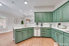 North Richland Hills house for rent - A kitchen with green cabinets and a white sink.