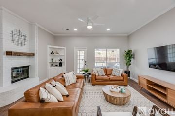 North Richland Hills house for rent - A living room with a brown leather couch and a fireplace.