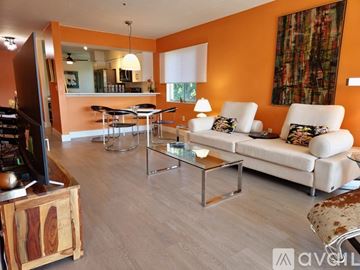 Sarasota apartment for rent - A living room with a white couch, a glass coffee table, and a television.