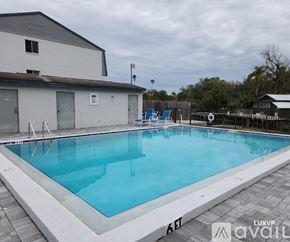 Sarasota apartment for rent - A large outdoor swimming pool with a white building in the background.
