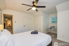 Houston house for rent - A bedroom with a white bed and a ceiling fan.