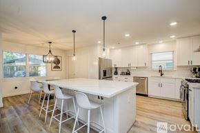 Houston house for rent - A kitchen with white cabinets and a large island.