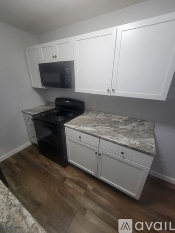 La Crosse apartment for rent - A kitchen with white cabinets and a black microwave.