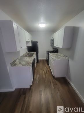 La Crosse apartment for rent - A kitchen with white cabinets and a wooden floor.