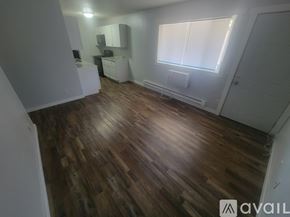 La Crosse apartment for rent - A room with wooden flooring and white walls.