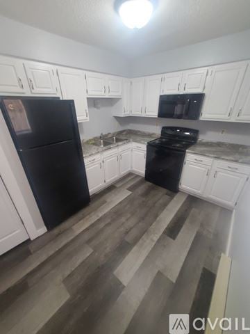 La Crosse apartment for rent - A kitchen with black appliances and white cabinets.