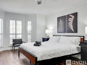 Allen house for rent - A bedroom with a bed, chair, and two paintings on the wall.