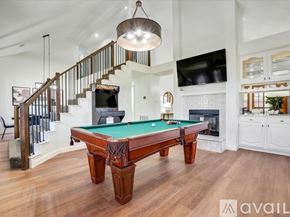 Allen house for rent - A pool table in a room with a staircase and a television.
