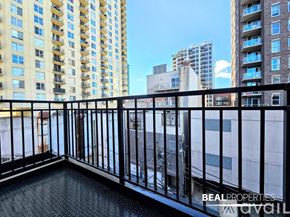 Chicago apartment for rent - A balcony with a black railing and a view of other buildings.