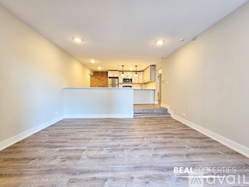 Chicago apartment for rent - A modern kitchen with a stainless steel refrigerator and a wooden floor.