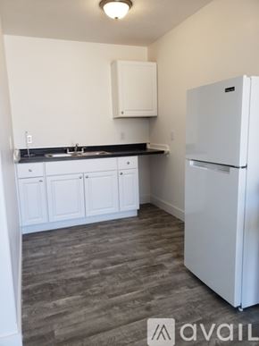 Green Forest apartment for rent - A kitchen with a white fridge and cabinets.