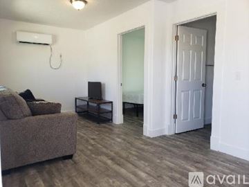 Green Forest apartment for rent - A living room with a brown couch and a television.