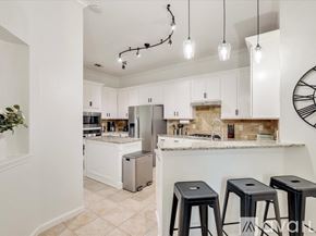 Rockwall house for rent - A kitchen with white cabinets and a marble countertop.